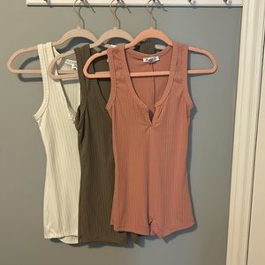 Pink, taupe, and white bodysuits